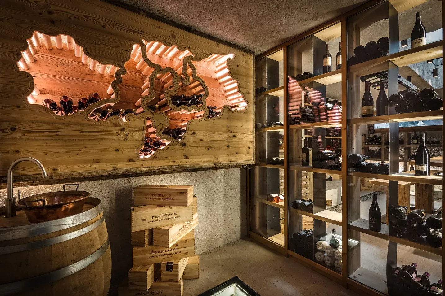 Saletta vinicola in legno con mappa neon illuminata alle pareti, scaffali in vetro e legno pieni di bottiglie, botti e casse di legno, atmosfera rustica.